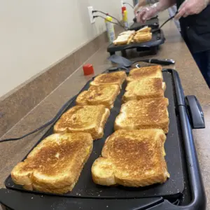 Team Leaders making grilled cheese for Team Members during DuraTech's annual Souper Bowl Lunch.